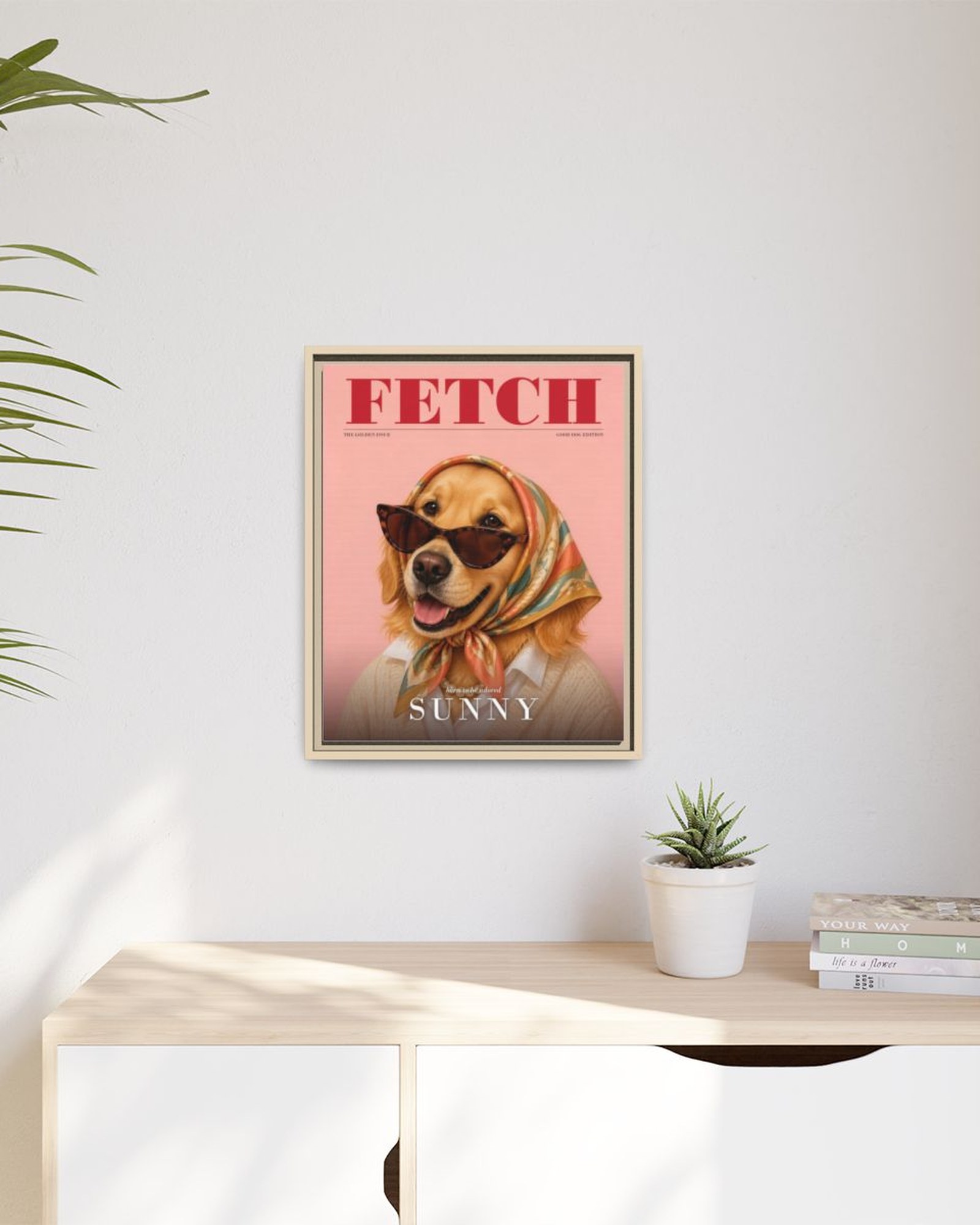 The framed magazine cover portrait hanging above a light wooden sideboard