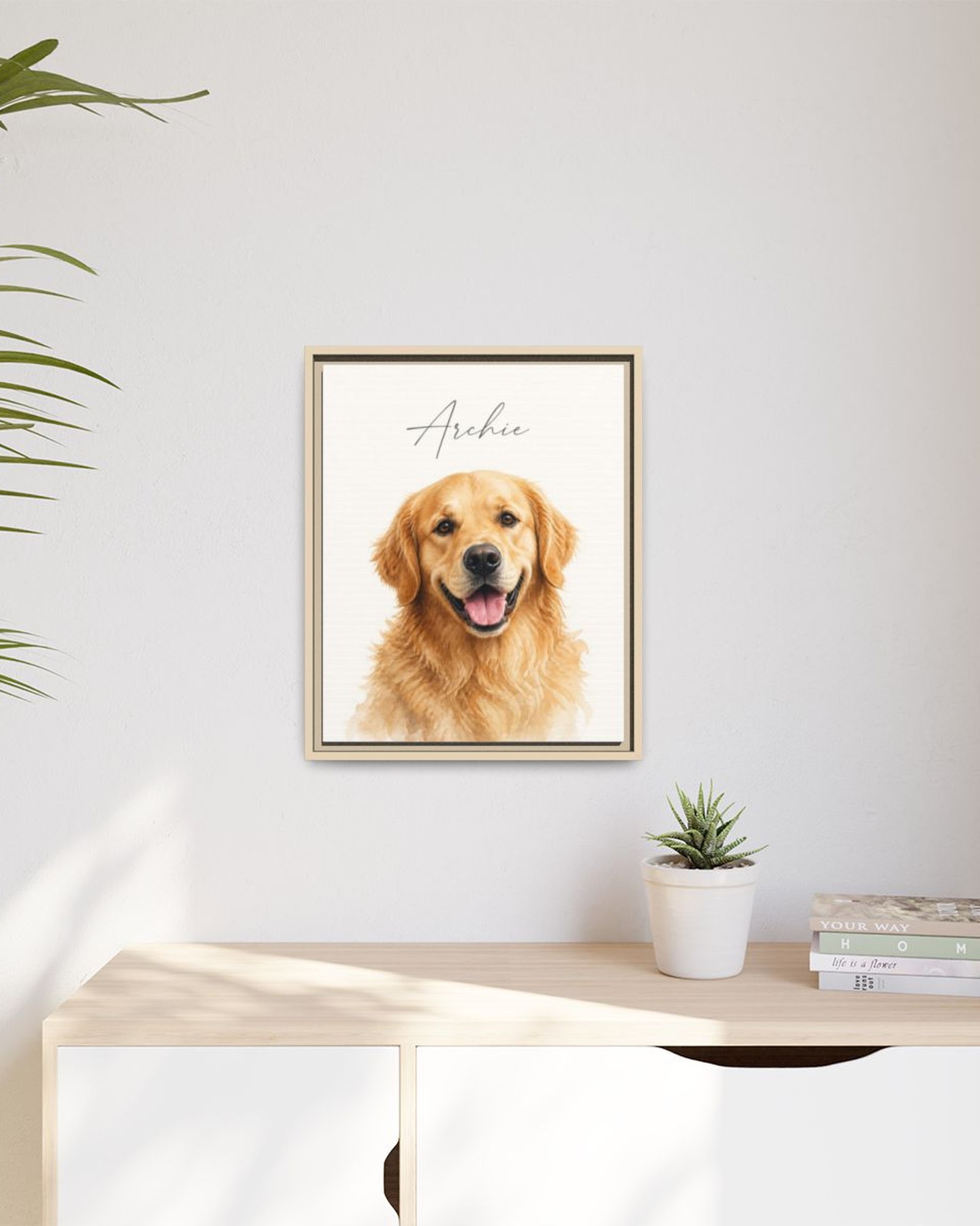 The framed watercolor portrait in a natural wood frame hanging above a light wooden sideboard