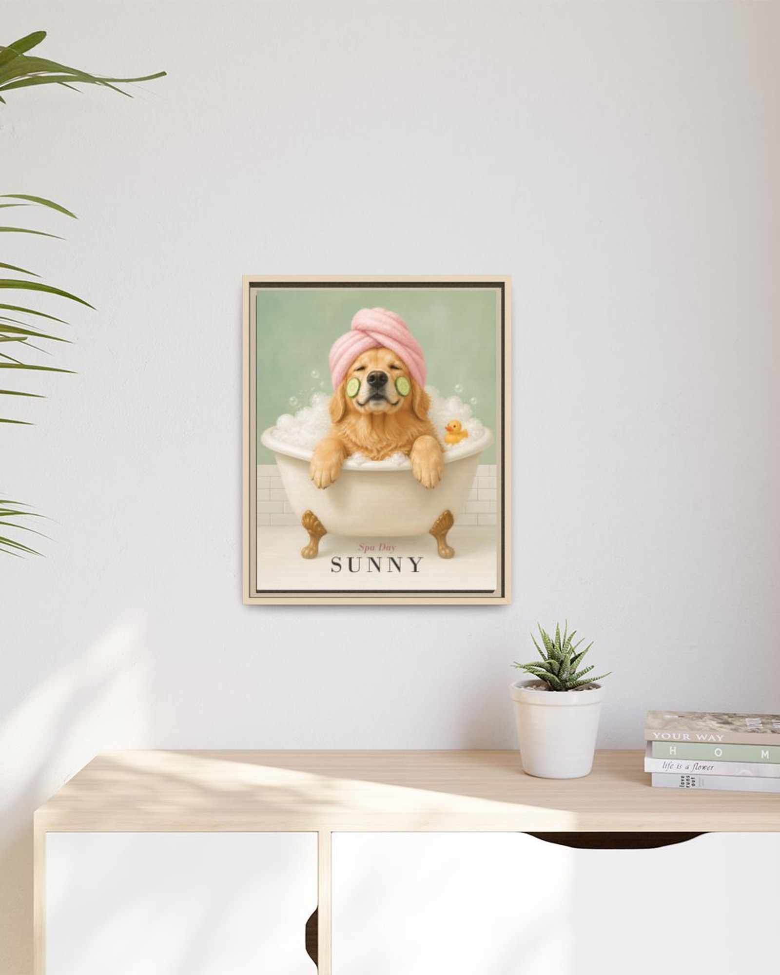 The framed portrait hanging above a light wooden sideboard