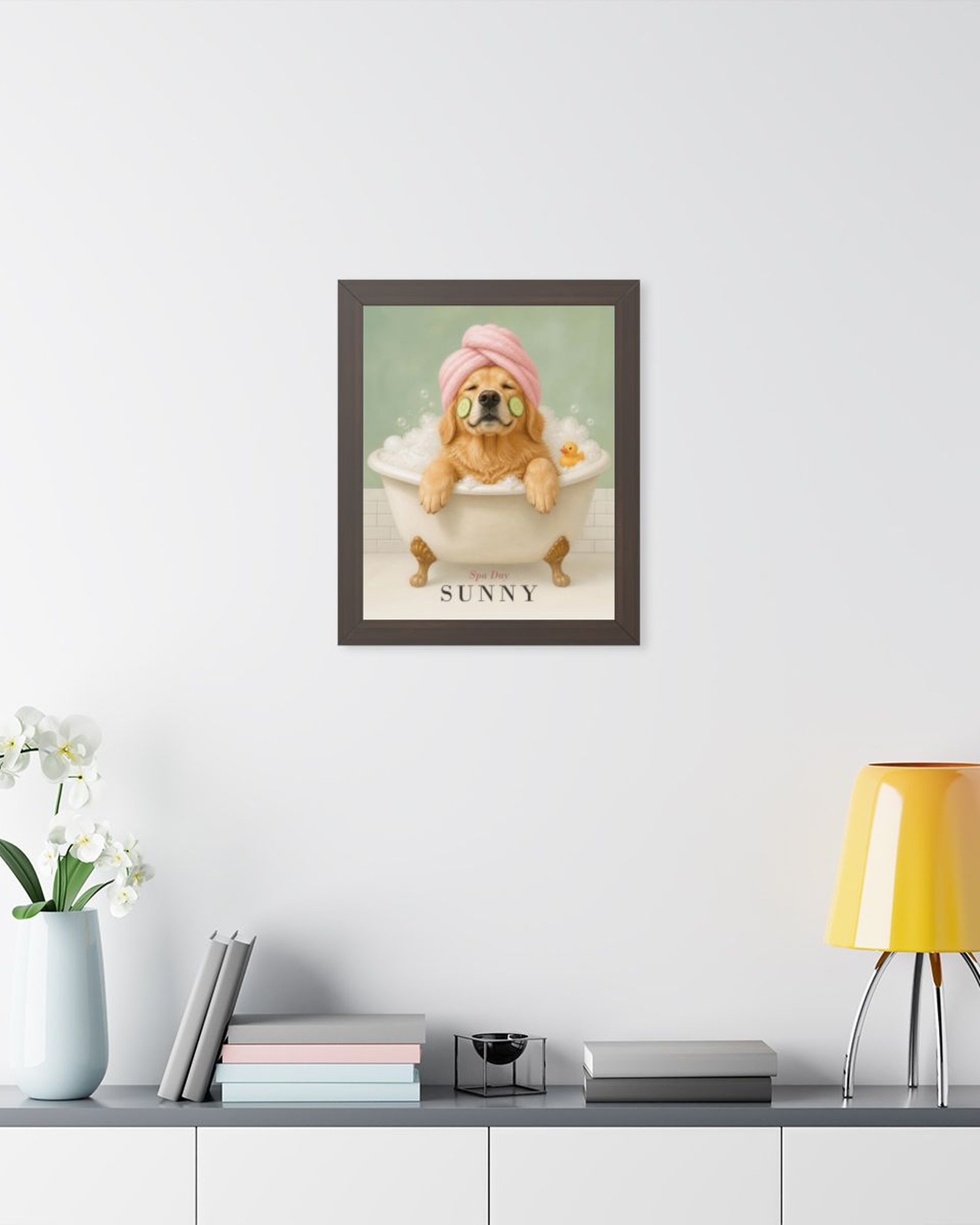 The walnut framed poster on a light gray wall above a white sideboard with plants